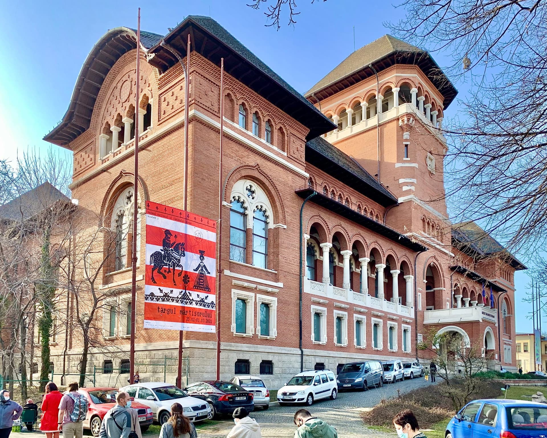 Fațada din cărămidă roșie a Muzeului Național al Țăranului Român din București, în stil neoromânesc, văzută de pe Șoseaua Kiseleff.