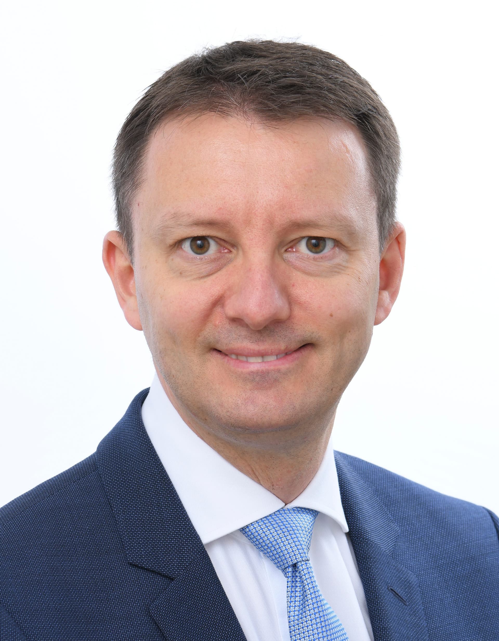 Portret oficial al europarlamentarului Siegfried Mureșan, în costum și cravată, fotografiat din față pe fundal neutru.